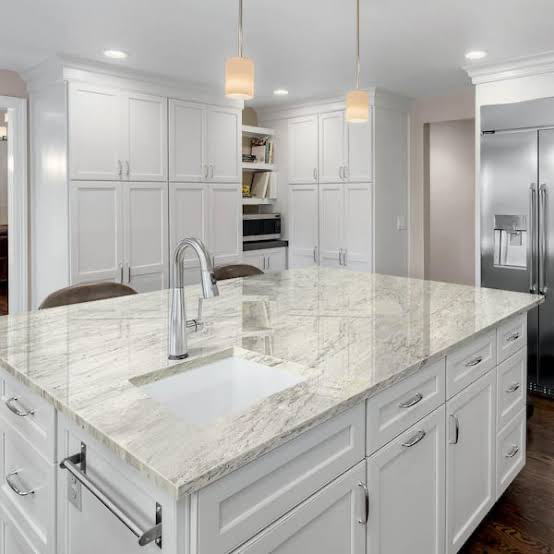 White kitchen island with granite countertop and sink by Amici Stone